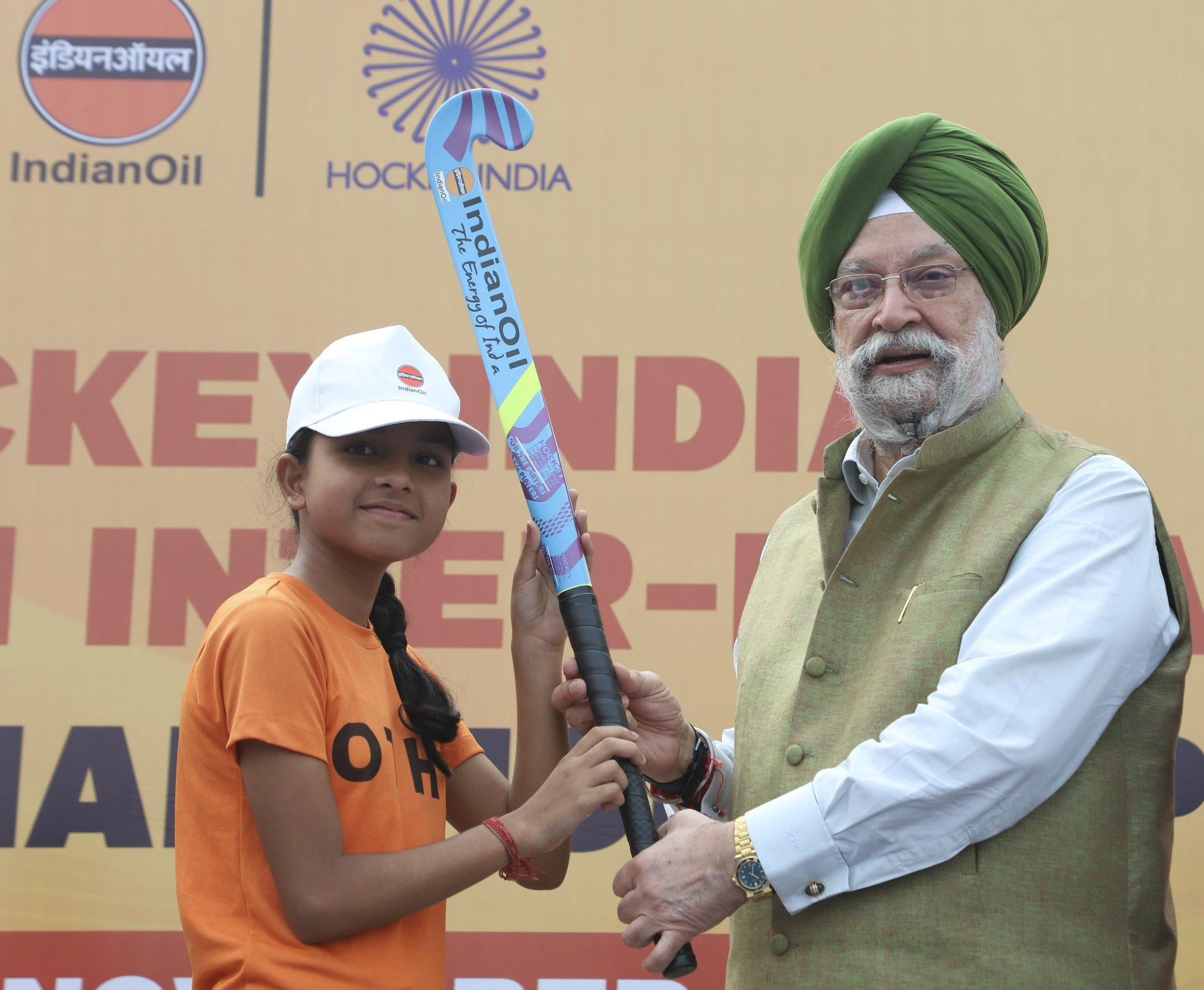 Union Minister Hardeep Singh Puri greeting an young hockey girl and gifting her a hockey stick